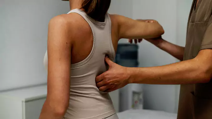 Modern concrete house with large glass windows overlooking a beach at sunset.